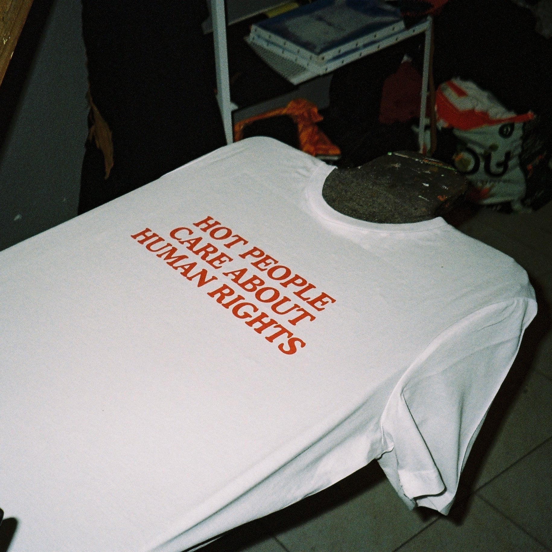 White t-shirt with red text on a dark surface